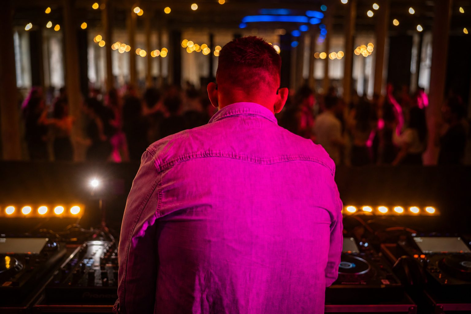 DJ JUVI zezadu, růžové světlo a tančící dav